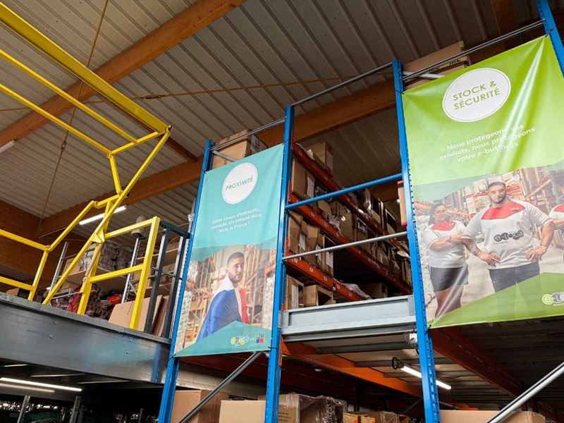 Entrepôt logistique d'Etxe Logistika, rayonnages de cartons et bannières de l'entreprise